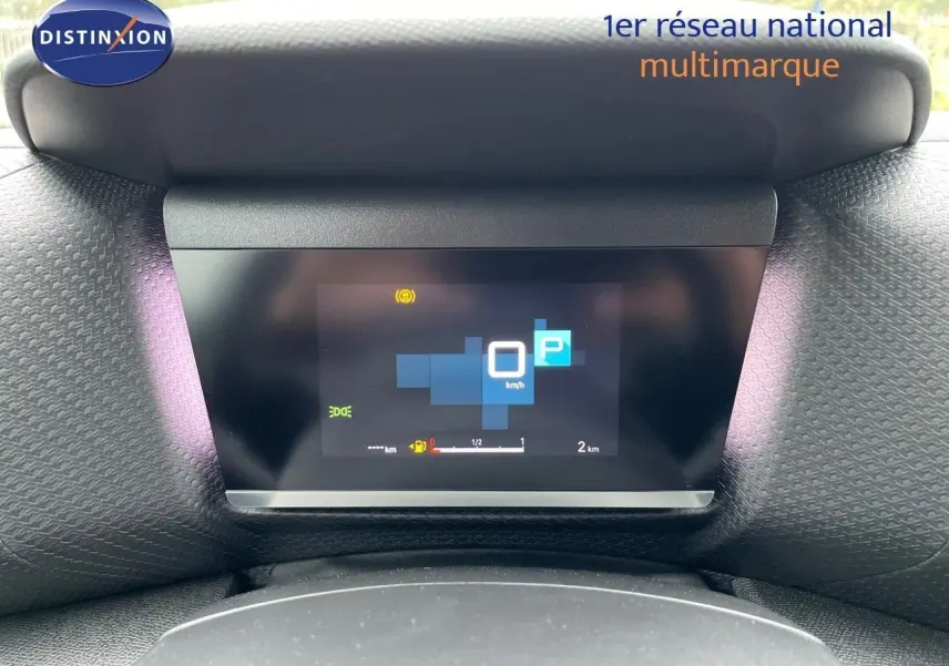 Tableau de bord numérique allumé d'une Citroën C4 blanche métal 2024, affichant la vitesse à 0 km/h en mode parking.