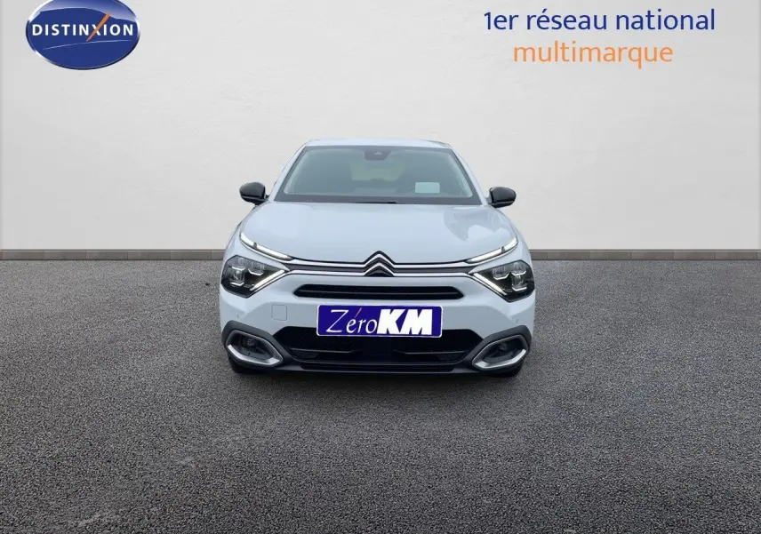 Citroën C4 blanc métal vue de face avec calandre distinctive et phares LED allumés sur fond neutre.