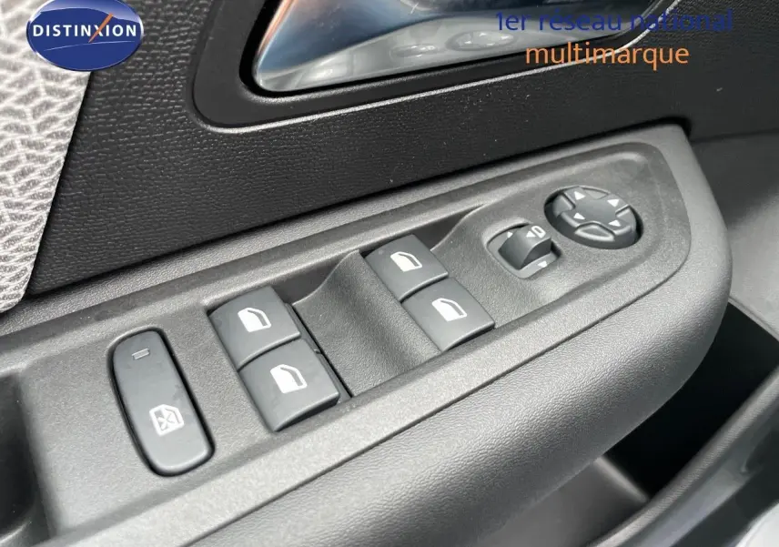 Gros plan sur les commandes des vitres et rétroviseurs côté gauche de la porte d’une Citroën C4 blanche métal 2024.