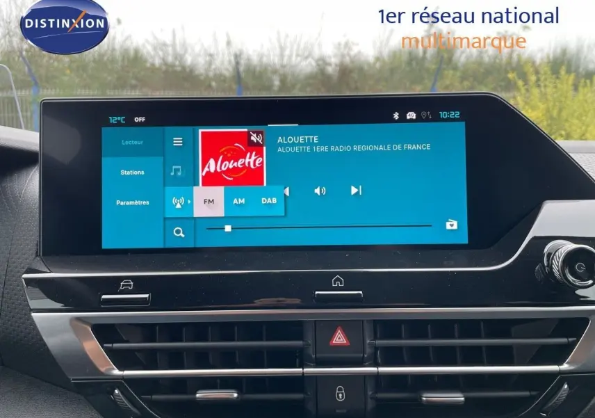 Écran tactile central du tableau de bord d'une Citroën C4 blanche métal 2024, affichant la radio Alouette.