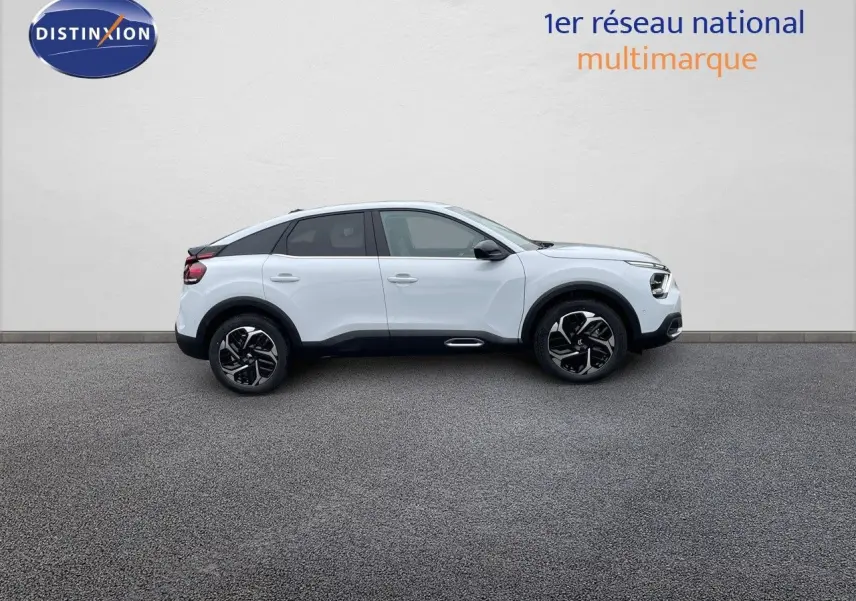 Profil droit d'une Citroën C4 blanche métallisée 2024 avec jantes biton et toit noir contrasté.