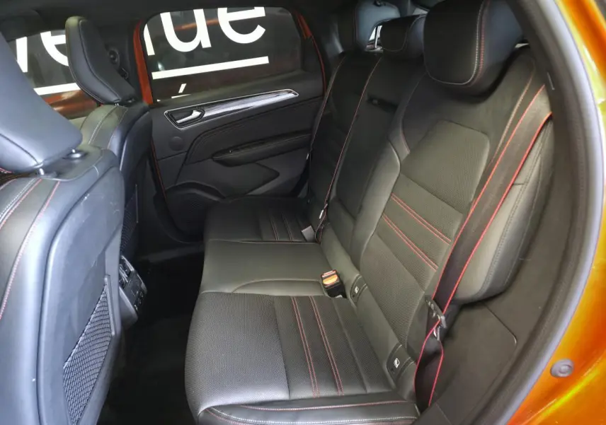 Vue intérieure côté droit sur la banquette arrière cuir noir avec surpiqûres rouges du Renault Arkana Orange Valencia 2024.