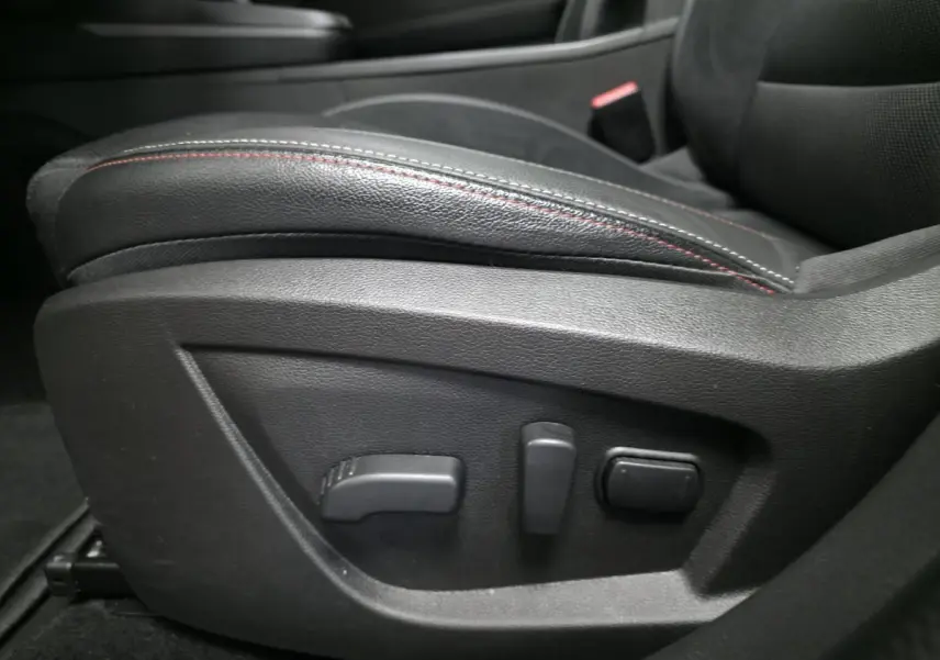 Gros plan sur les commandes électriques du siège avant en cuir noir avec surpiqûres rouges du Renault Arkana R.S. Line 2024.