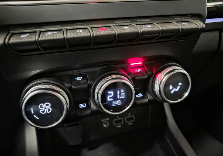 Gros plan sur les commandes de climatisation automatique du Renault Arkana 2024 avec affichage digital et boutons rétroéclairés.