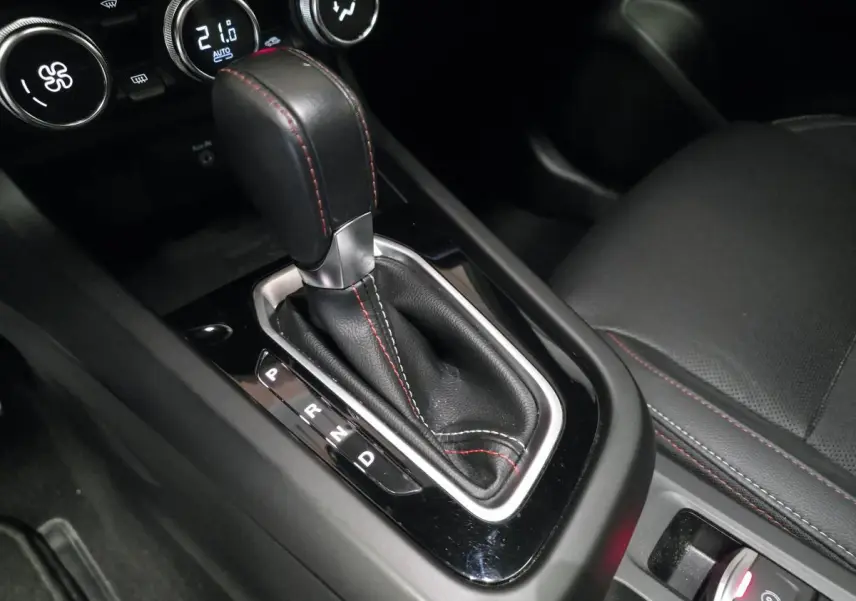 Gros plan sur la commande de boîte automatique noire avec surpiqûres rouges dans l'habitacle du Renault Arkana R.S. Line 2024.