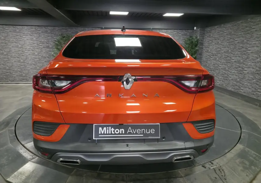 Vue arrière d'une Renault Arkana orange Valencia avec feux reliés et double sortie d'échappement chromée.