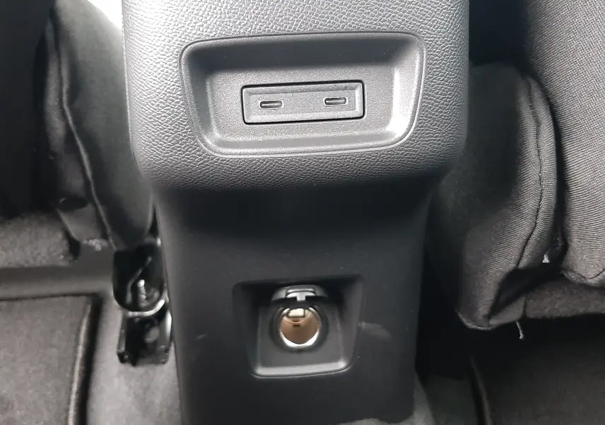 Prise USB double et prise 12V en gros plan sur la console centrale arrière d'un Citroën C3 Aircross gris Mercury.