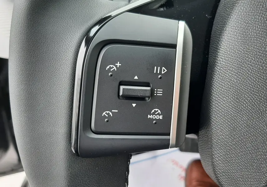 Gros plan sur les commandes de régulateur de vitesse au volant noir du Citroën C3 Aircross gris Mercury 2025.