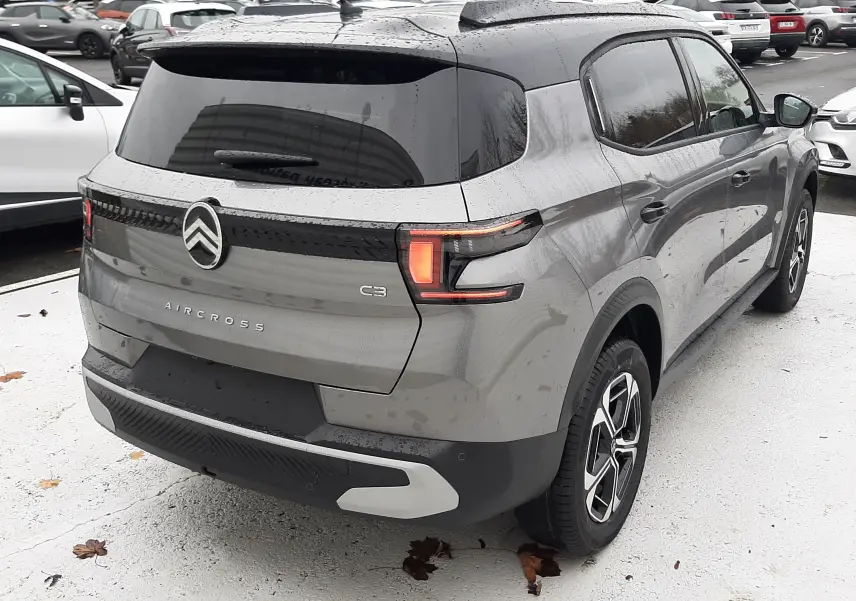 Vue 3/4 arrière droite d'un Citroën C3 Aircross gris Mercury avec toit noir, feux arrière LED et jantes biton.