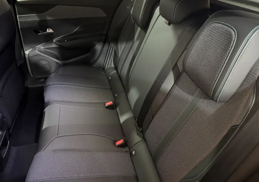 Vue intérieure côté droit montrant la banquette arrière noire avec surpiqûres contrastantes du Peugeot 308 2025.
