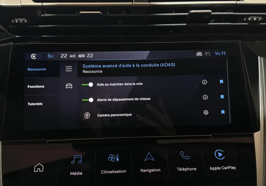 Écran tactile central de la Peugeot 308 rouge, affichant les aides à la conduite avancées, vue intérieure frontale.