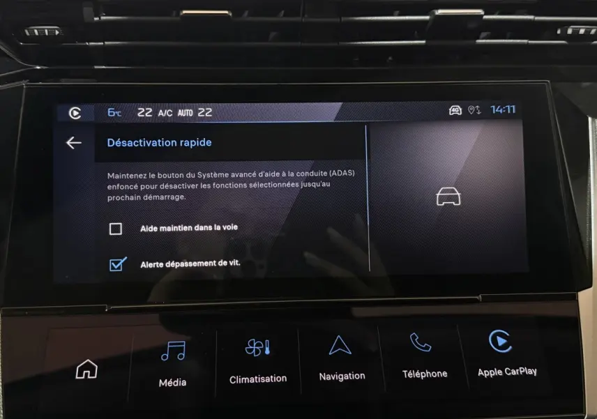 Écran tactile central de la Peugeot 308 rouge, affichant les options d'aide à la conduite et climatisation.