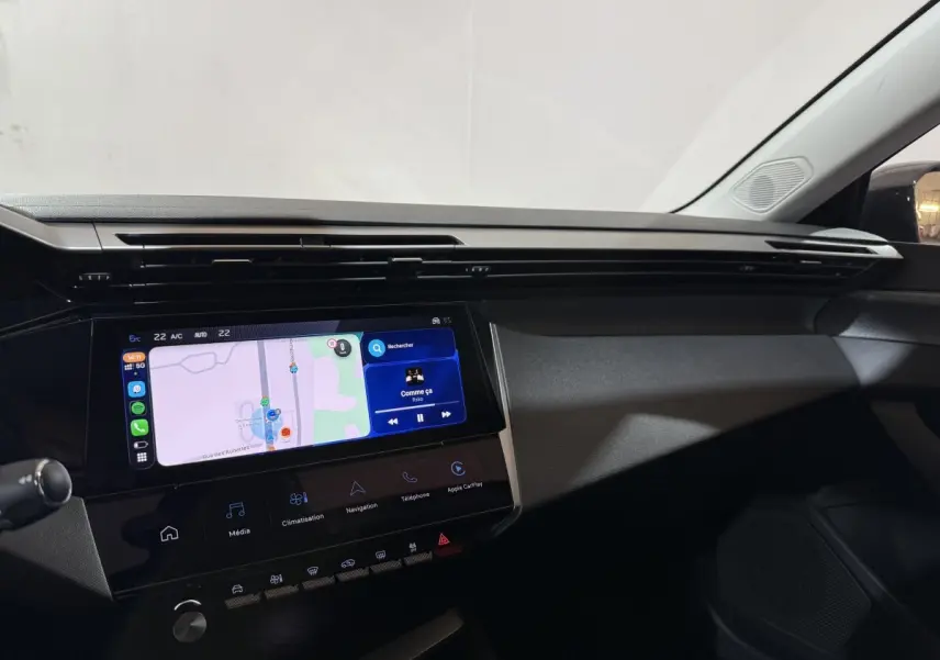 Vue intérieure du tableau de bord de la Peugeot 308 2025 avec écran tactile central affichant une navigation et interface multimédia.