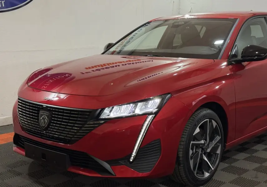 Peugeot 308 BlueHDi 130 Allure rouge vue de 3/4 avant droit, avec calandre noire et phares LED distinctifs.