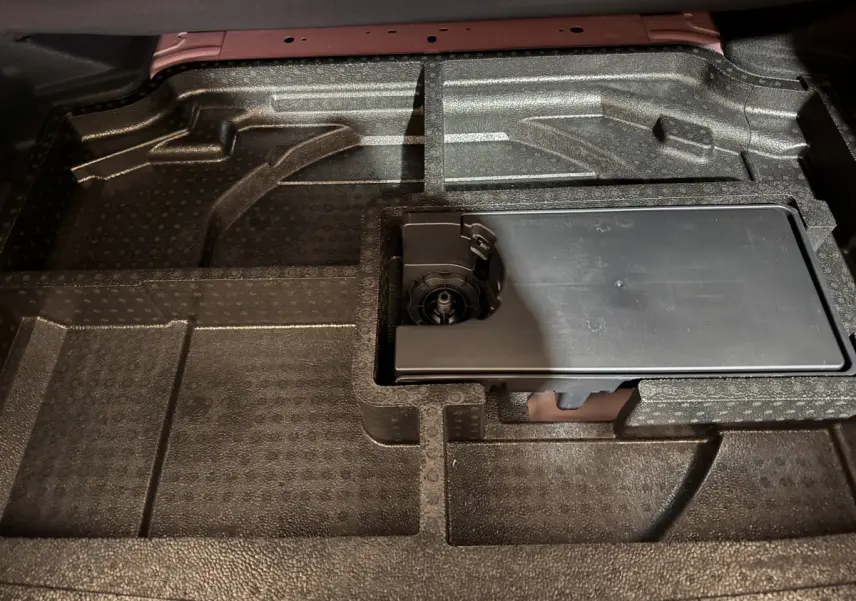 Vue rapprochée du rangement sous tablette dans le coffre de la Peugeot 308 rouge 2025 BlueHDi 130 AUTO8 ALLURE.