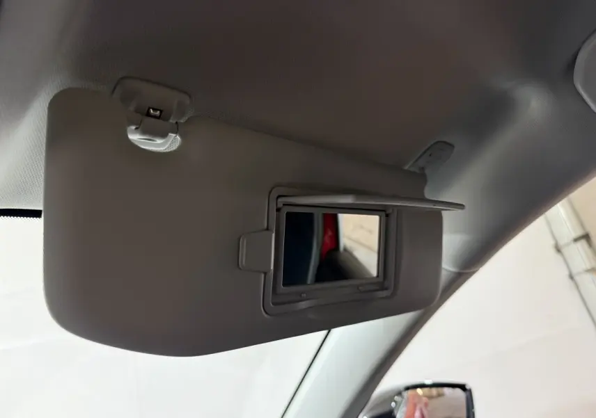 Miroir de courtoisie ouvert sur pare-soleil côté conducteur, intérieur gris, reflet d’une portière rouge Peugeot 308.