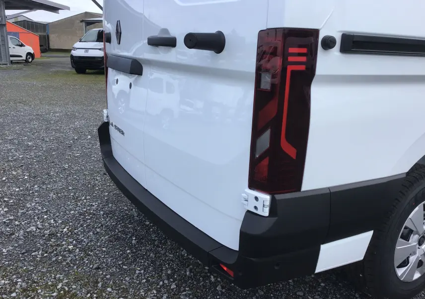 Vue arrière droite du Renault Master blanc 2025, mettant en valeur le feu arrière et le pare-chocs noir robuste.