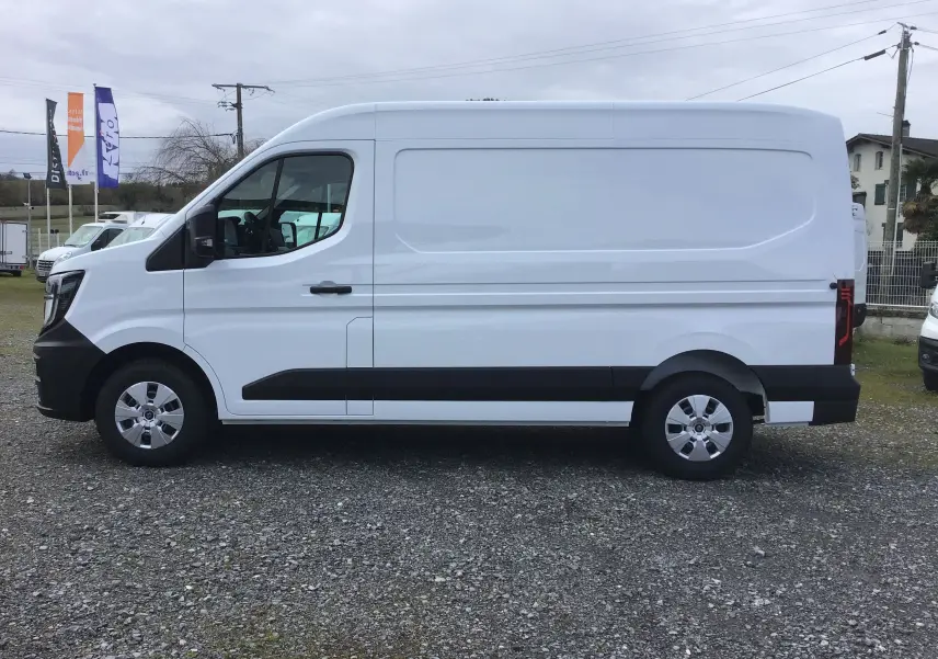 Vue de profil côté gauche d’un Renault Master blanc, fourgon utilitaire avec protections noires sur les bas de caisse.