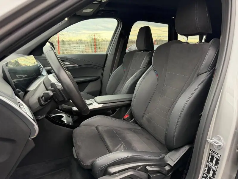 Vue intérieure côté conducteur du BMW X1 XDrive20d 2025 en Spacesilber métal, sièges sport en alcantara noir avec surpiqûres.