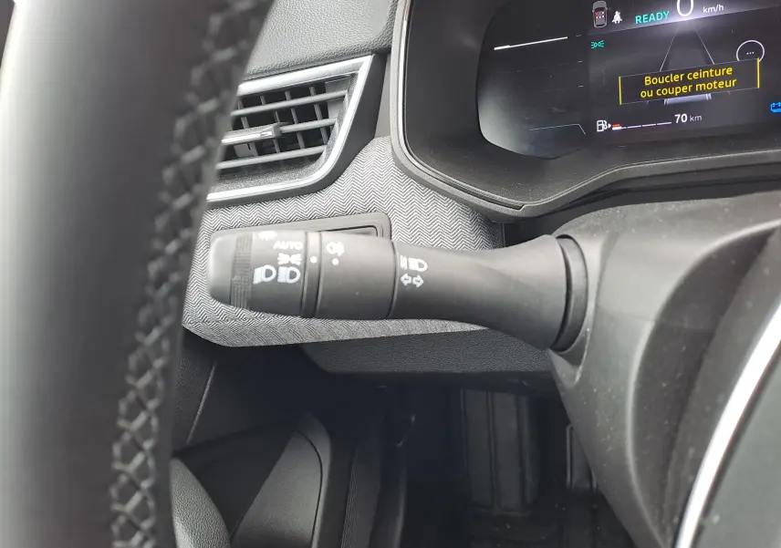 Détail intérieur du commodo d’éclairage à gauche du volant dans une Renault Clio V hybride 2025, finition Technotech.