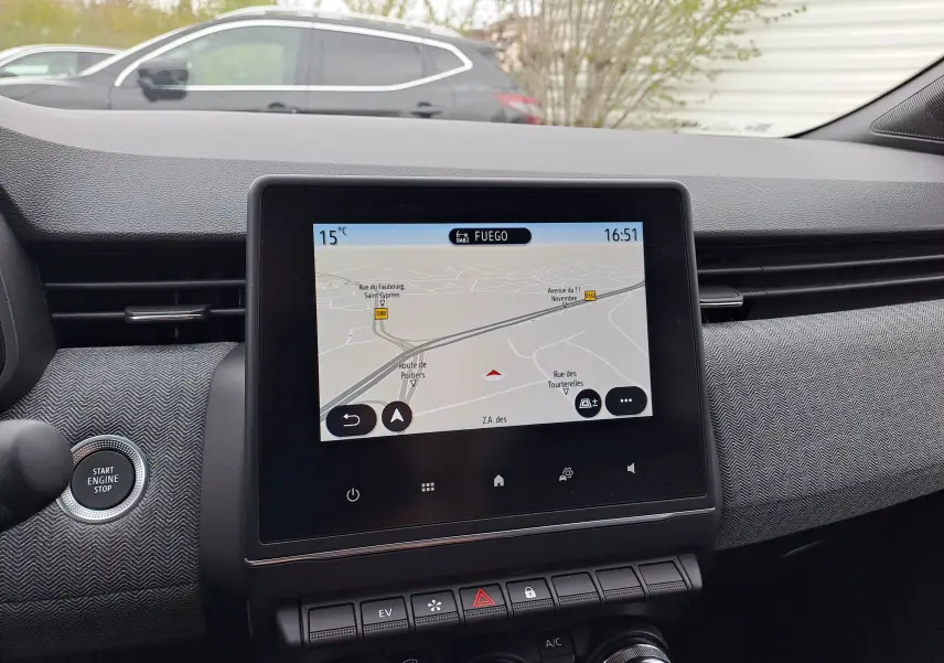 Vue intérieure centrée sur l'écran tactile du tableau de bord de la Renault Clio V, affichant la navigation GPS.