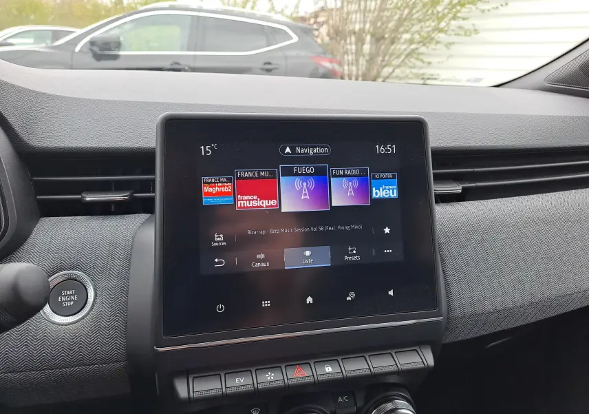 Vue intérieure centrée sur l'écran tactile du tableau de bord de la Renault Clio V hybride, avec bouton start visible.