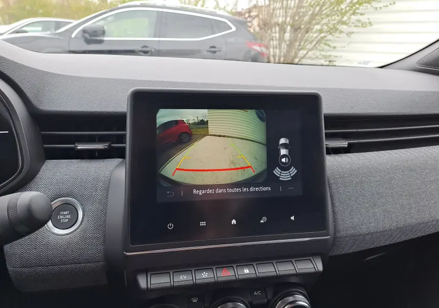 Vue intérieure du tableau de bord de la Renault Clio V bleu iron metal, écran affichant la caméra de recul avec guidage.