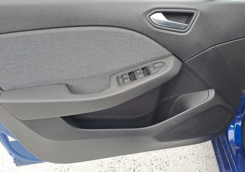 Vue rapprochée de la porte avant gauche de la Renault Clio V bleu Iron Metal, avec commandes des vitres et poignée intérieure.