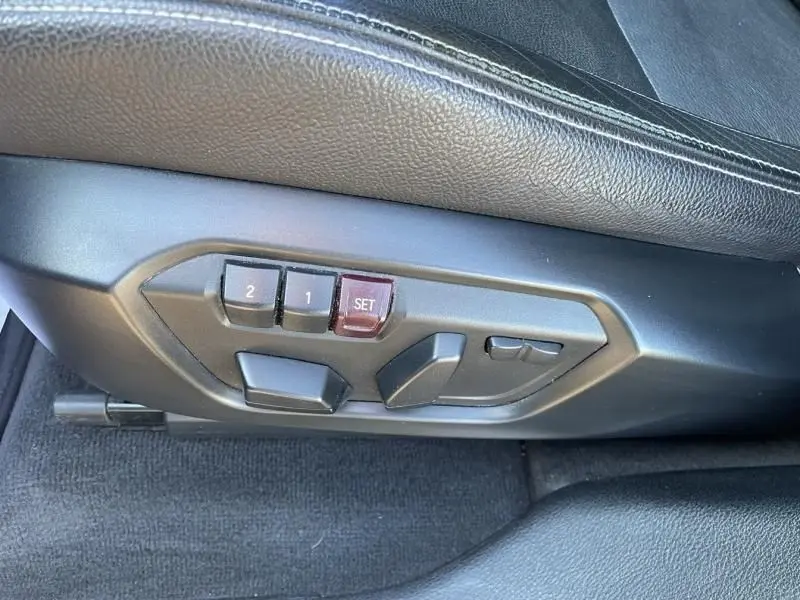 Détail des commandes de réglage électrique du siège côté gauche d'une BMW X4 30DA X DRIVE noir métal de 2016.