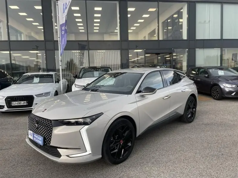 DS4 hybride rechargeable gris en vue 3/4 avant droit, avec calandre distinctive et jantes noires Performance Line.