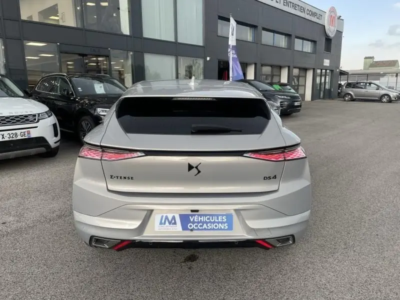 Vue arrière d'une DS4 gris métallisé 2023 hybride rechargeable E-Tense avec feux arrière fins et logo DS central.