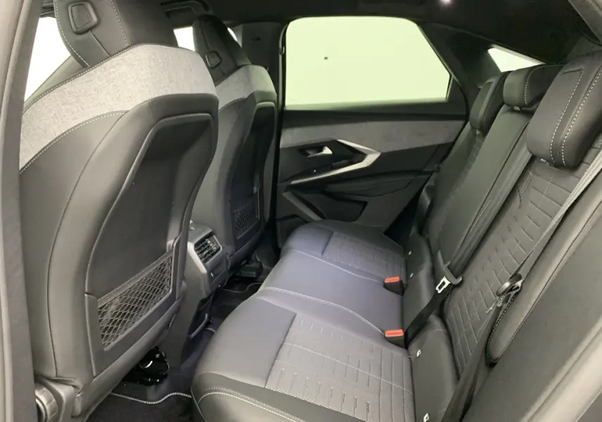 Vue intérieure côté droit des sièges arrière en tissu et cuir noir avec surpiqûres blanches du Peugeot 3008 Hybrid 2025.