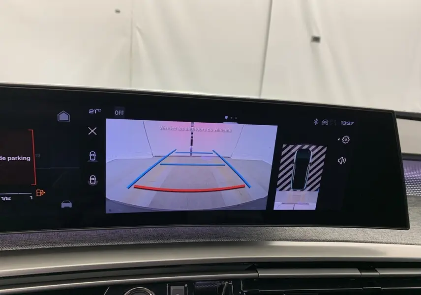 Écran central du Peugeot 3008 Hybrid 2025 affichant la caméra de recul avec lignes de guidage et vue 360° intérieure.