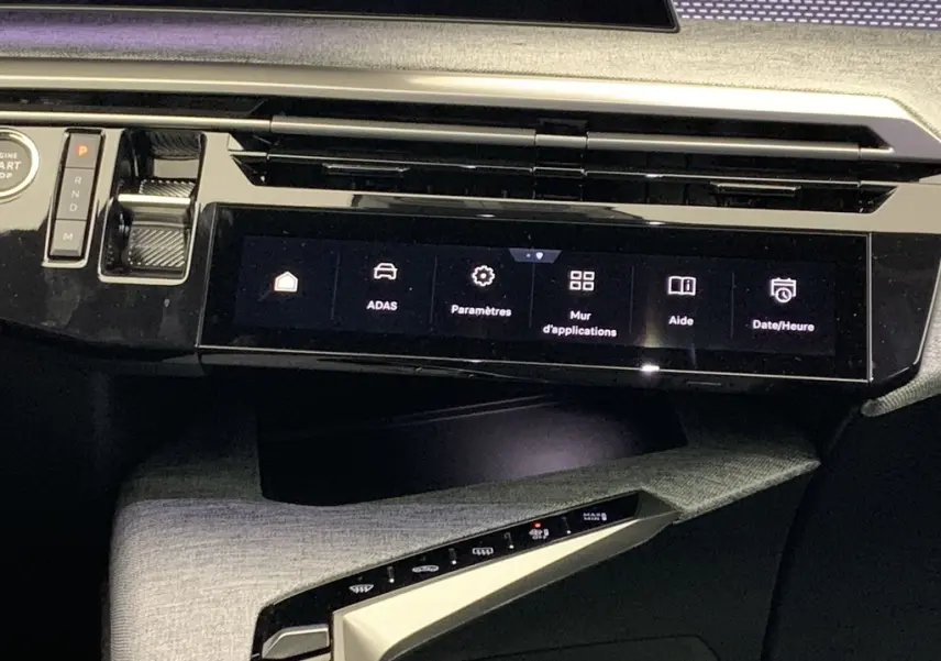Vue rapprochée de la console centrale noire laquée avec écran tactile et commandes du Peugeot 3008 Hybrid 2025.