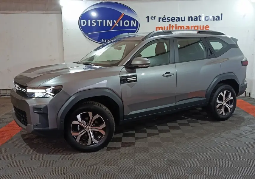SUV Dacia Bigster gris foncé vu de profil côté gauche, avec jantes alliage et feux LED allumés.