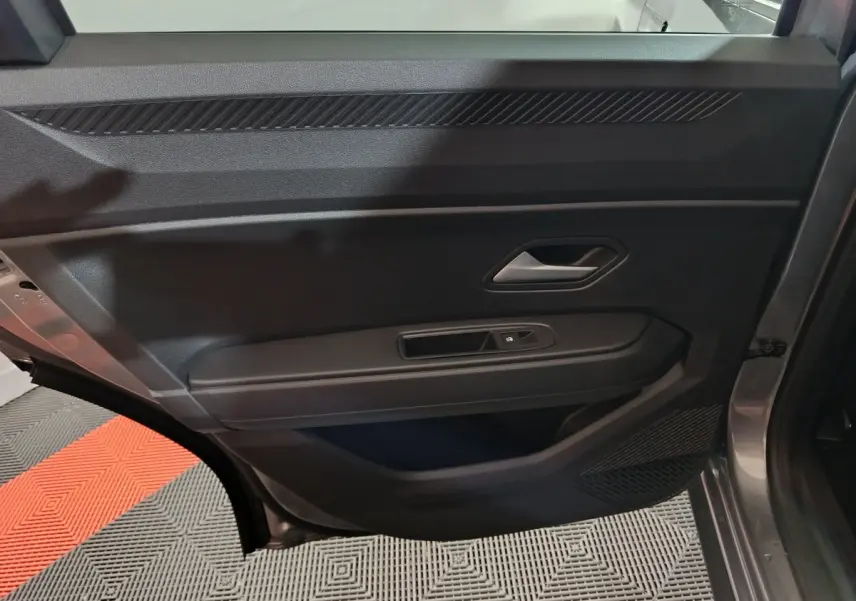 Vue intérieure de la porte arrière droite grise du Dacia Bigster 2025, avec commande de vitre et poignée intégrée.