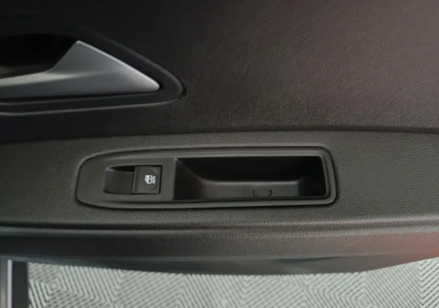 Détail de la poignée intérieure côté gauche de la porte d'une Dacia Bigster gris foncé, avec bouton de verrouillage.