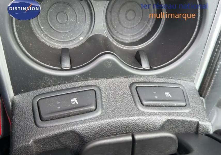 Gros plan sur les boutons de sièges chauffants noirs et porte-gobelets dans l’habitacle du Renault Kadjar gris Highland.