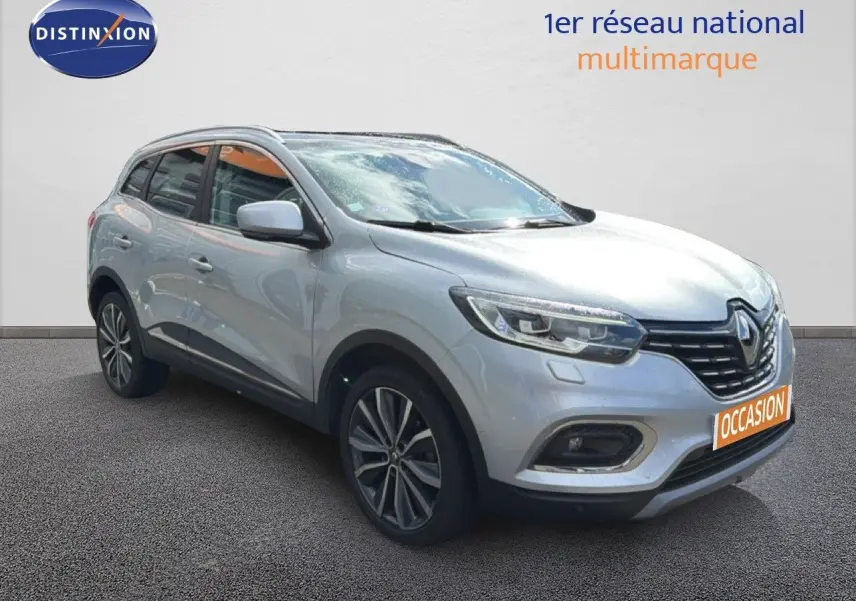 Renault Kadjar gris Highland en 3/4 avant droit, SUV compact avec jantes alliage et calandre noire distinctive.
