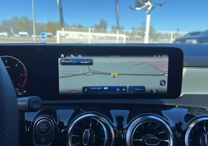 Vue intérieure du tableau de bord de la Mercedes Classe A 200D, écran GPS central et aérateurs ronds noirs brillants.