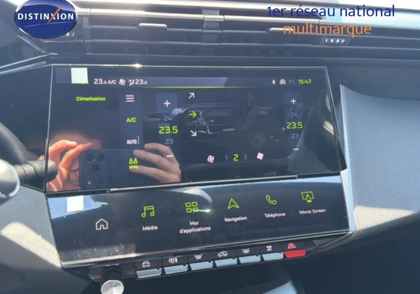 Vue rapprochée de l’écran tactile central du tableau de bord du Peugeot 308 Hybrid noir perle métal, affichant la climatisation et les applications multimédia.