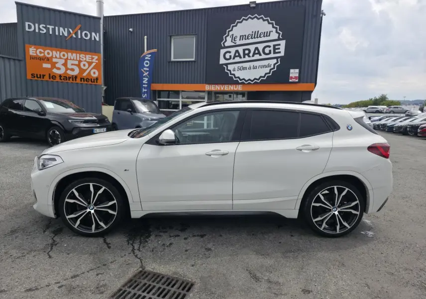 BMW X2 sDrive 18d blanc vue de profil côté gauche avec jantes M Sport noires à rayons doubles.