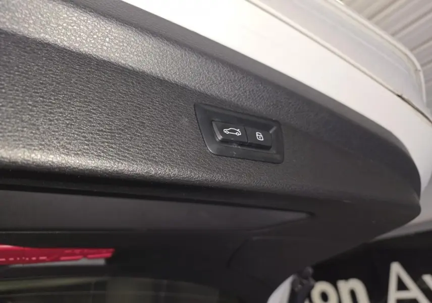 Bouton de commande électrique du hayon sur la bordure intérieure du coffre d’une BMW X2 blanche.