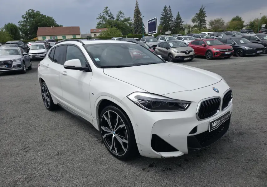 BMW X2 sDrive 18d blanc vue 3/4 avant droit avec jantes alliage 20'' style M et calandre noire sportive.