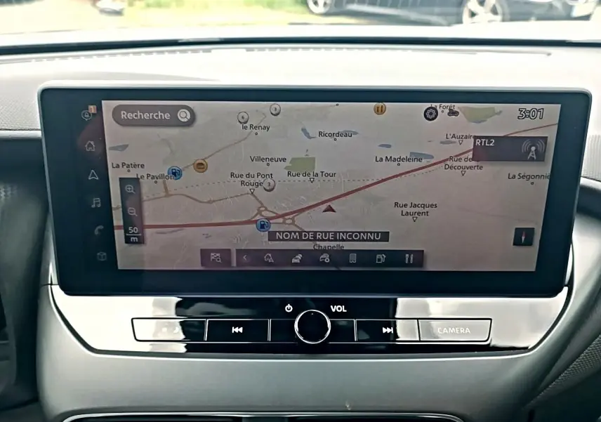 Écran tactile central affichant la navigation du Nissan Juke 2025, intérieur gris avec commandes audio intégrées.