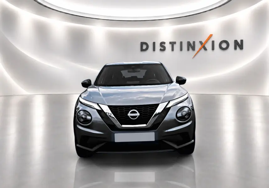 Vue avant d'un Nissan Juke gris 2025 dans un showroom avec éclairage moderne et logo Distinxion en arrière-plan.