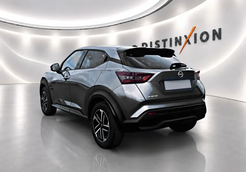 Nissan Juke gris en 3/4 arrière droit dans un showroom lumineux avec jantes alu et feux arrière LED.