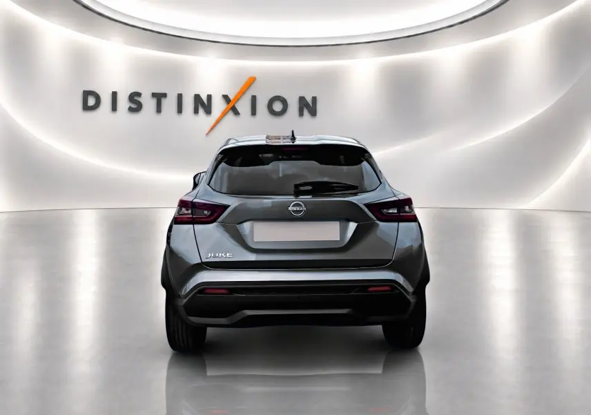Vue arrière d'un Nissan Juke gris 2025 dans un studio lumineux avec logo Distinxion en arrière-plan.