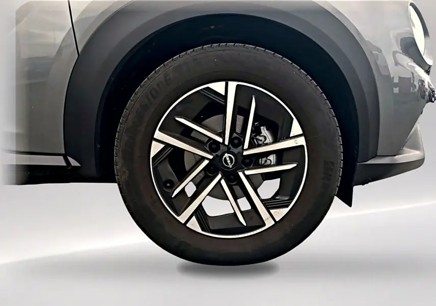 Gros plan sur la roue avant droite gris métallisé du Nissan Juke 2025 avec jante alliage noire et argent.