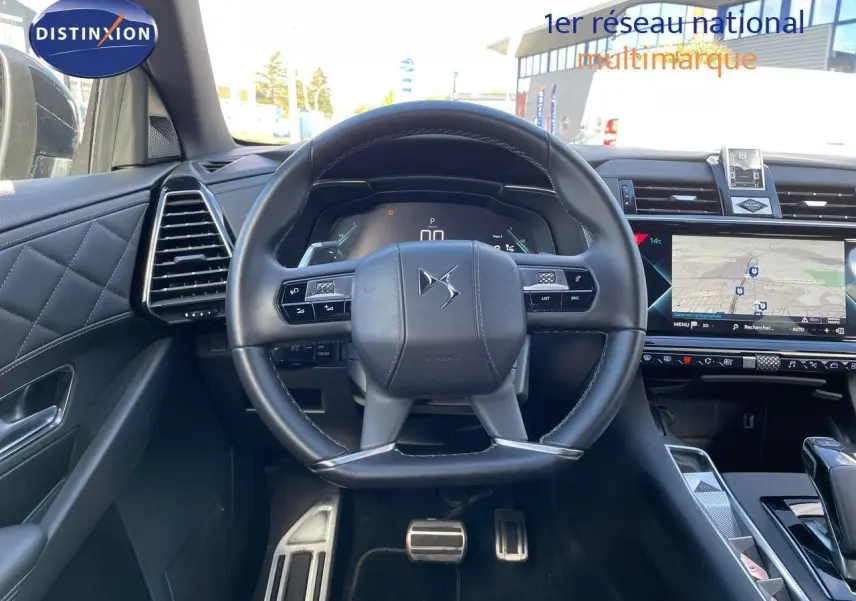 Vue intérieure centrée sur le volant cuir noir du DS7 Crossback E-TENSE 2021 avec tableau de bord digital et écran tactile GPS.